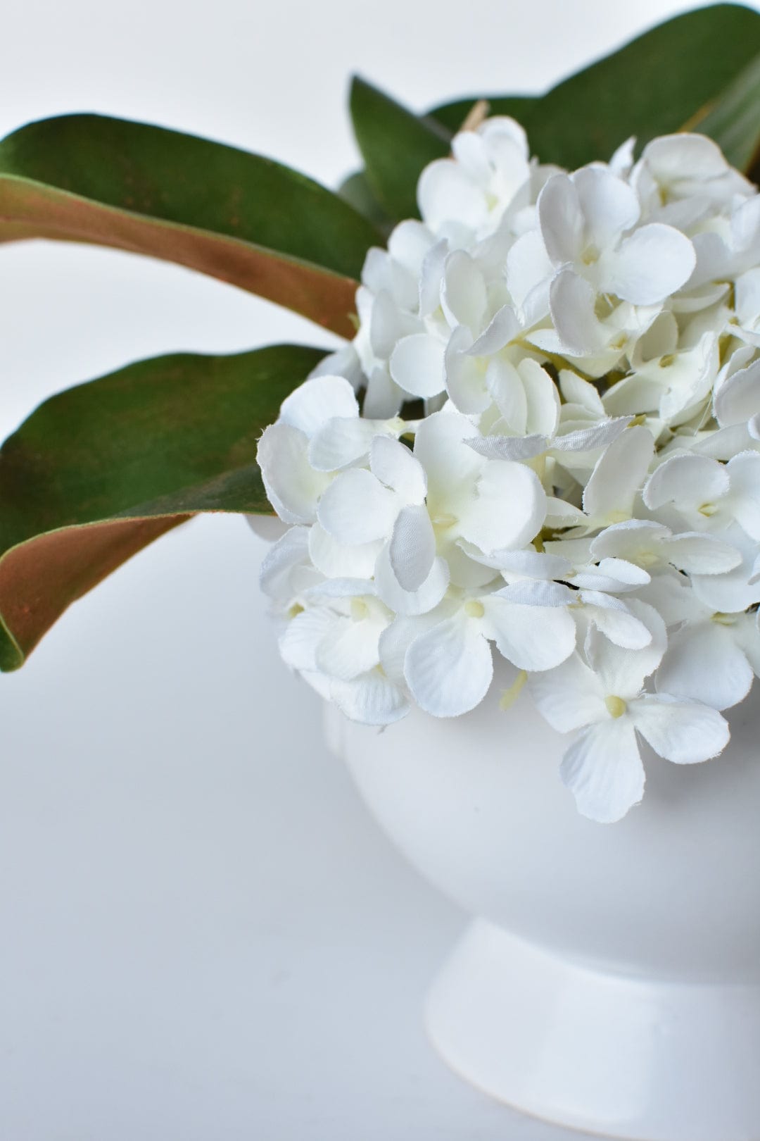 White Hydrangea + Magnolia Leaf Arrangement with Faux Ring Details